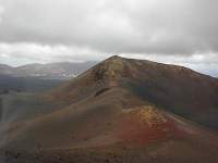 12 Timanfaya park.jpg: Tussen alle lava door zijn er toch nog vele verschillende kleuren te onderscheiden op de bergen. Dit wordt veroorzaakt door de verschillende metalen die zich in de grond bevinden.